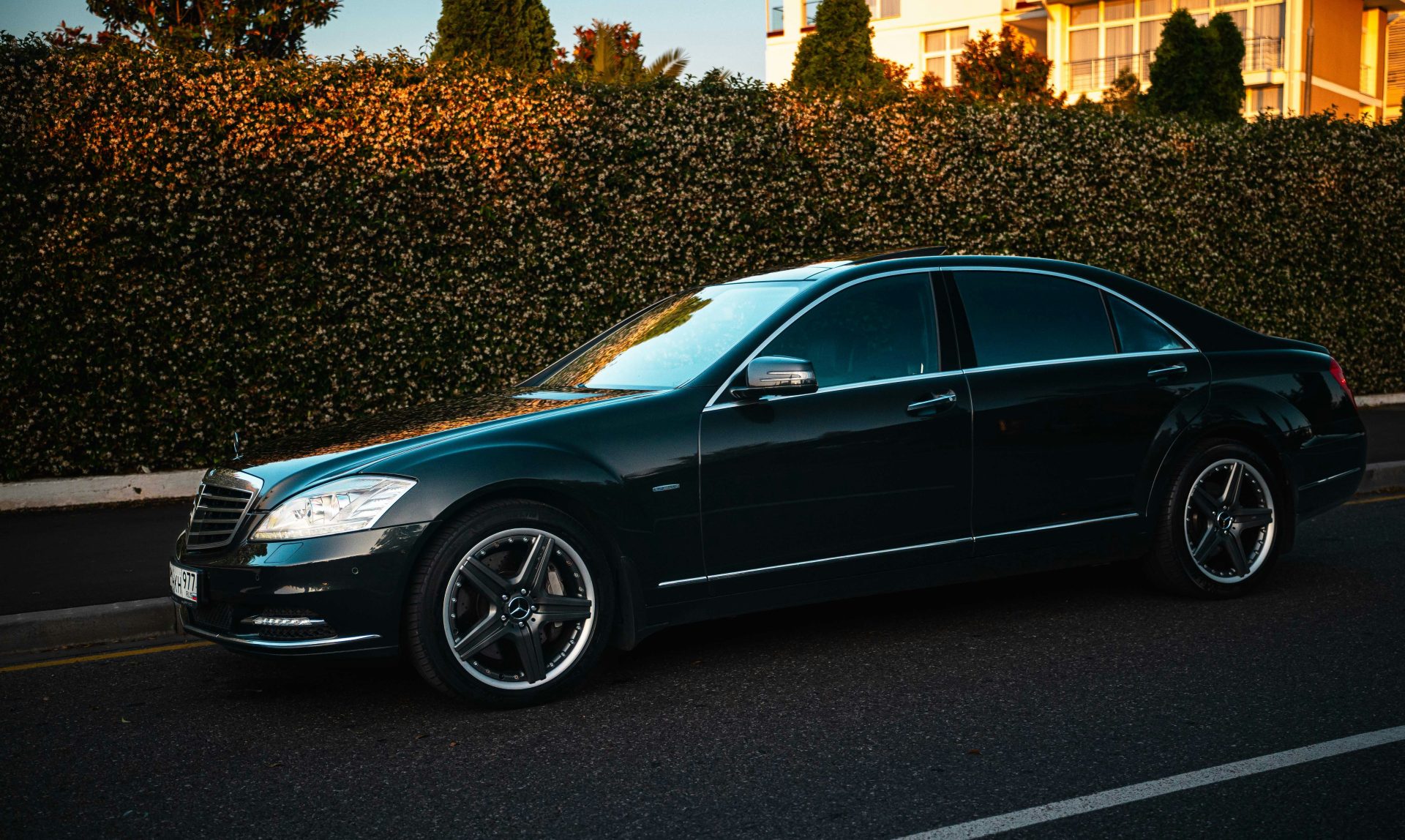 A dark luxury sedan parked on a street.